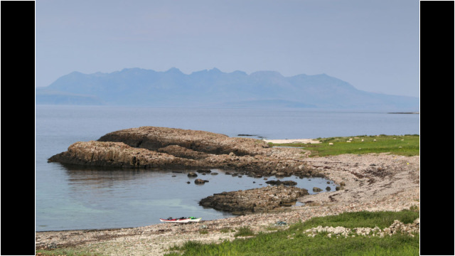 Garrisdale NW Canna, Cuillin of Skye behind Sea Kayak Canna