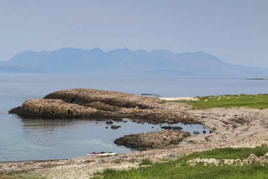 Garrisdale NW Canna, Cuillin of Skye behind Sea Kayak Canna